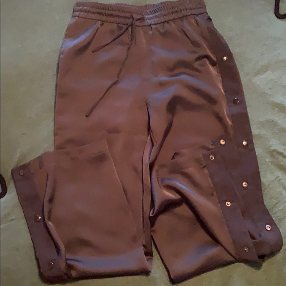 Black silk material trousers, button side detail